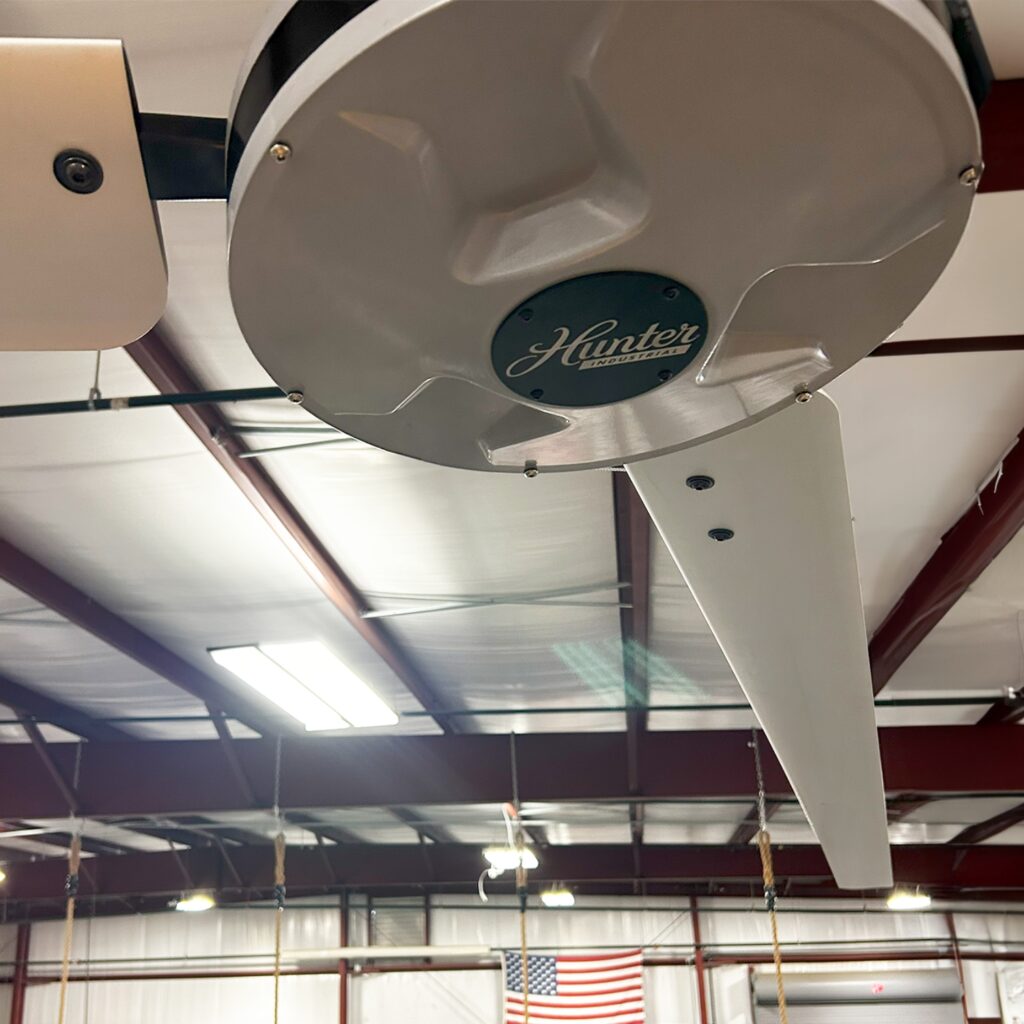 Moteur blanc Hunter vu de dessous sur le déstratificateur d'un hall sportif de collectivité