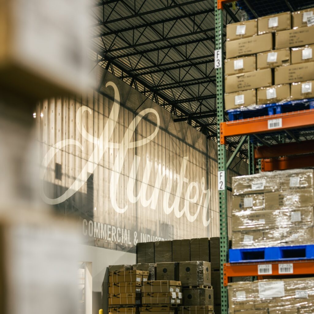 Enseigne lumineuse Hunter dans un entrepôt de stockage aux cartons empilés sur racks