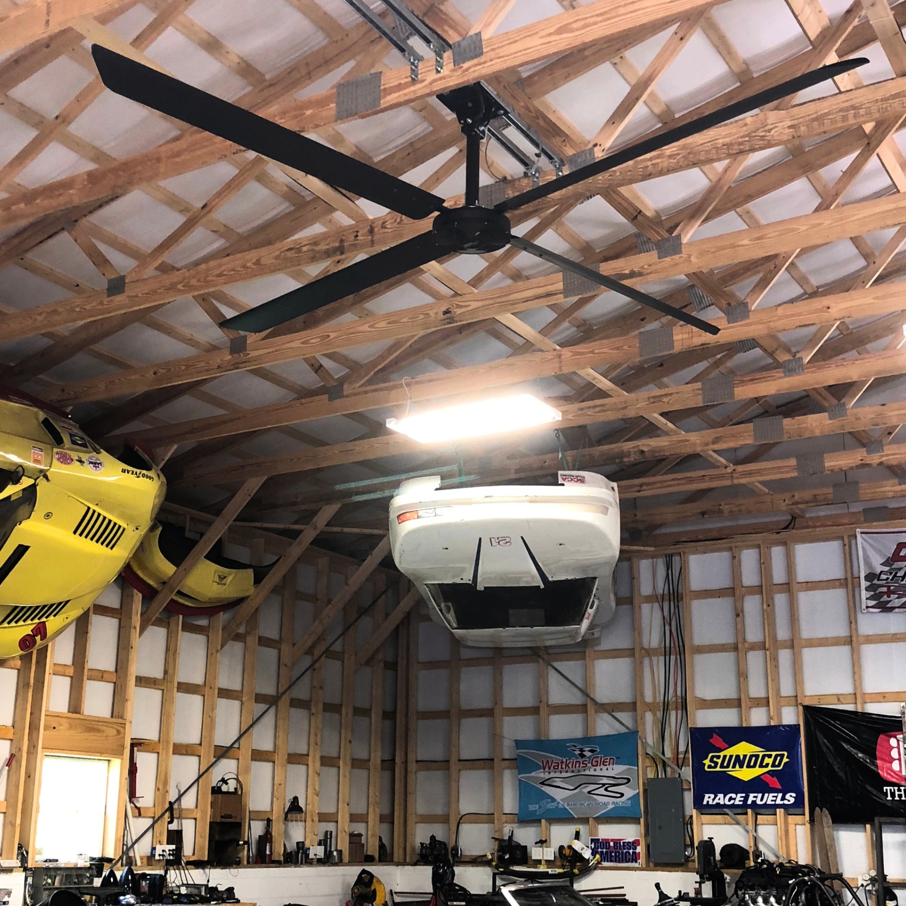 Déstratificateur Hunter RM sous la charpente bois d'un hangar abritant un avion léger