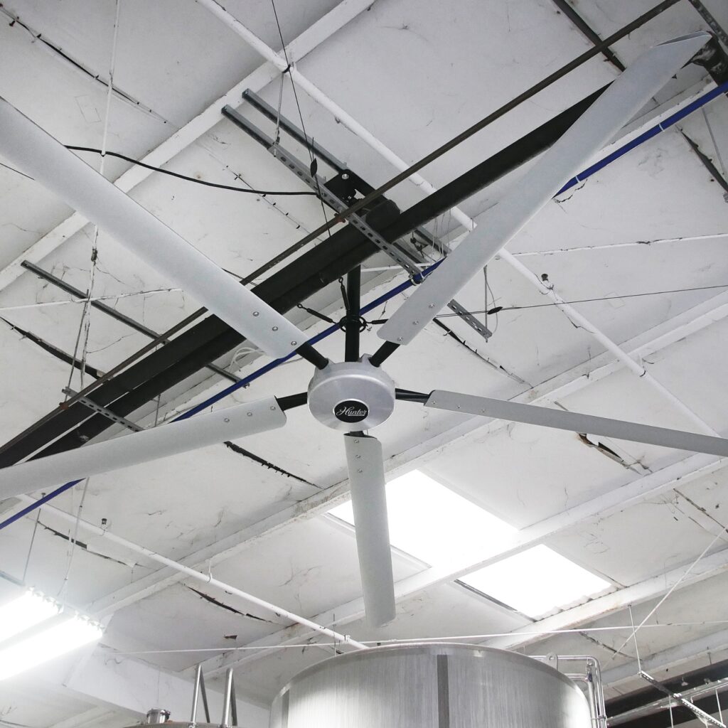 Déstratificateur Hunter Titan au-dessus d'un atelier de production, plafond technique apparent