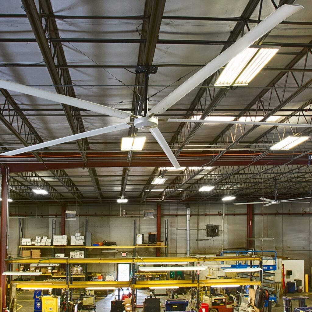 Ventilateur HVLS Hunter au-dessus des machines jaunes d'un atelier de production