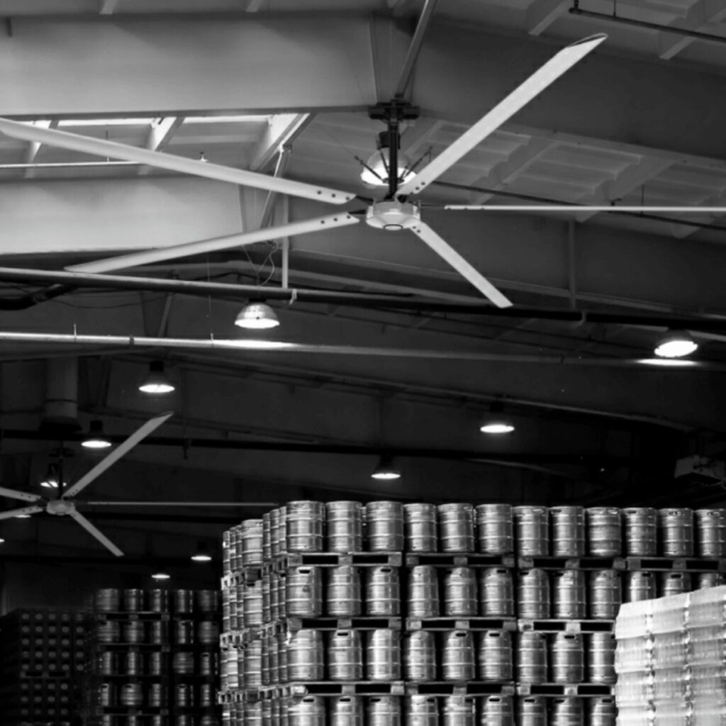 Ventilateur HVLS dans une brasserie artisanale au-dessus des fûts de bière